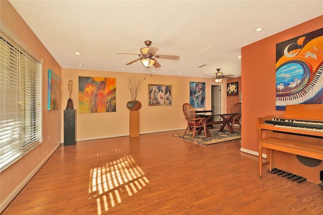 interior space with wood-type flooring, a textured ceiling, and ceiling fan