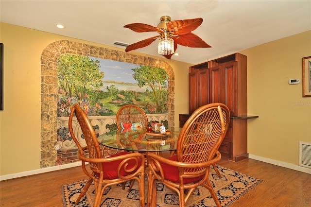 dining space with hardwood / wood-style floors and ceiling fan