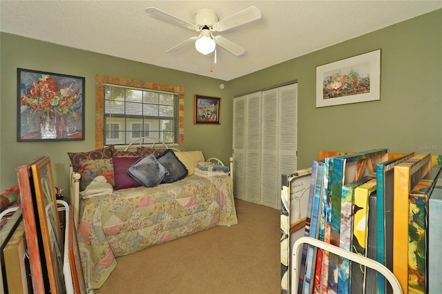 carpeted bedroom featuring ceiling fan and a closet