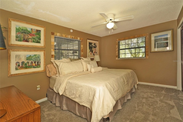 carpeted bedroom with ceiling fan and a textured ceiling