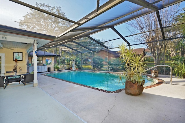 view of swimming pool with ceiling fan, a lanai, and a patio