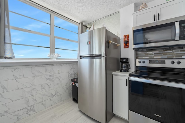 kitchen featuring white cabinets, appliances with stainless steel finishes, and a textured ceiling