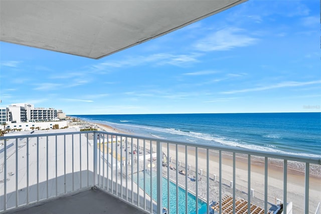 balcony with a water view and a beach view