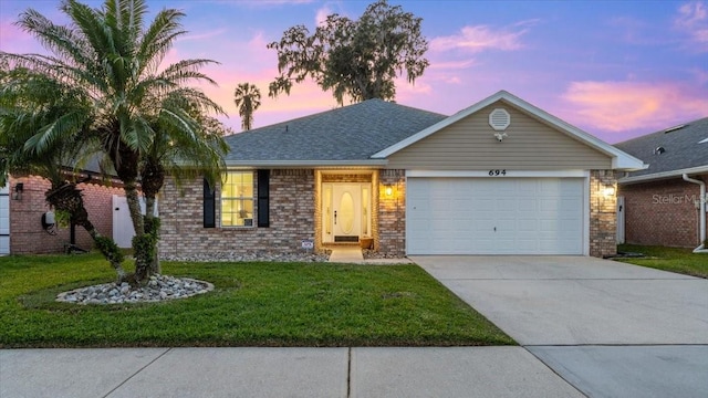 ranch-style house featuring a yard and a garage