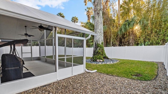 view of yard featuring a sunroom, a patio, and ceiling fan