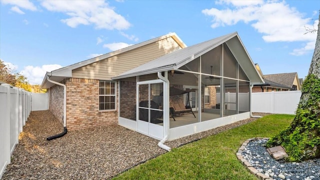 back of house with ceiling fan, a yard, and a sunroom