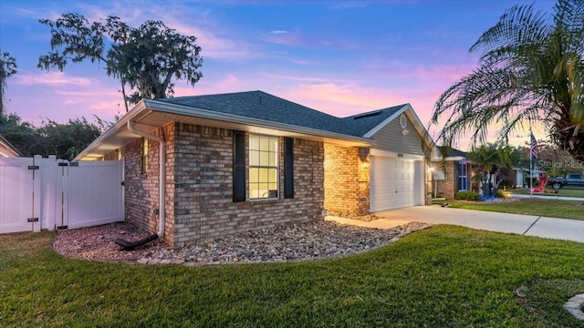 ranch-style house with a garage and a yard