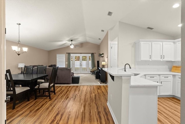 kitchen with white cabinetry, french doors, light hardwood / wood-style floors, sink, and kitchen peninsula