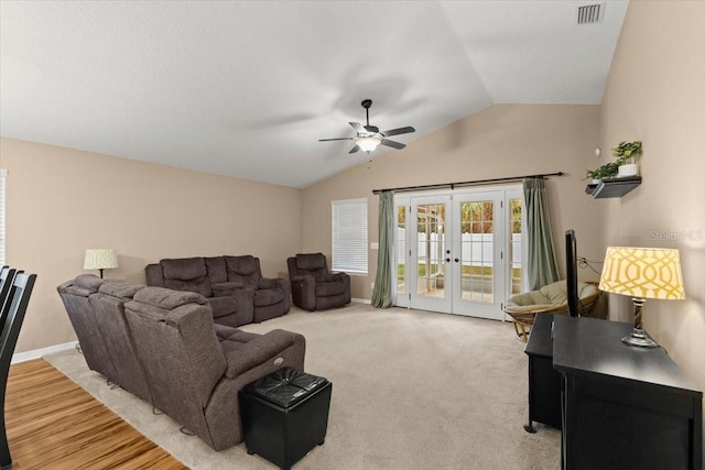 carpeted living room featuring vaulted ceiling, ceiling fan, and french doors