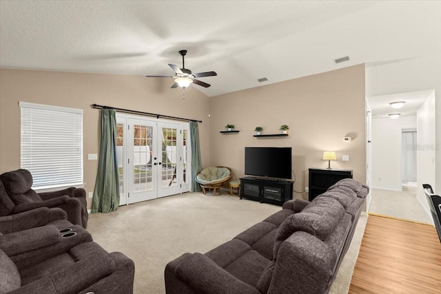 living room featuring ceiling fan, light colored carpet, lofted ceiling, and french doors