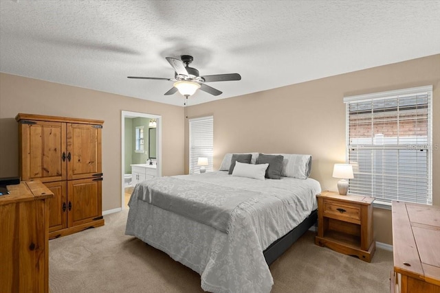 carpeted bedroom featuring ceiling fan, a textured ceiling, and ensuite bathroom