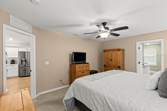 carpeted bedroom featuring stainless steel fridge with ice dispenser, ceiling fan, and connected bathroom