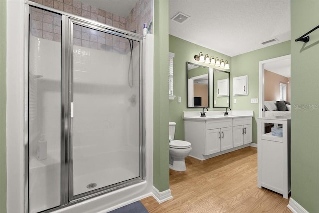 bathroom featuring hardwood / wood-style floors, an enclosed shower, vanity, and toilet