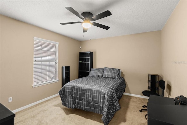 bedroom featuring ceiling fan, light colored carpet, and a textured ceiling