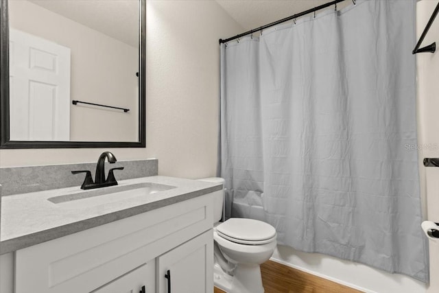 full bathroom featuring wood-type flooring, toilet, vanity, and shower / tub combo with curtain