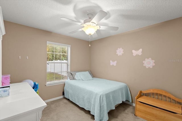 bedroom featuring ceiling fan, a textured ceiling, and light carpet