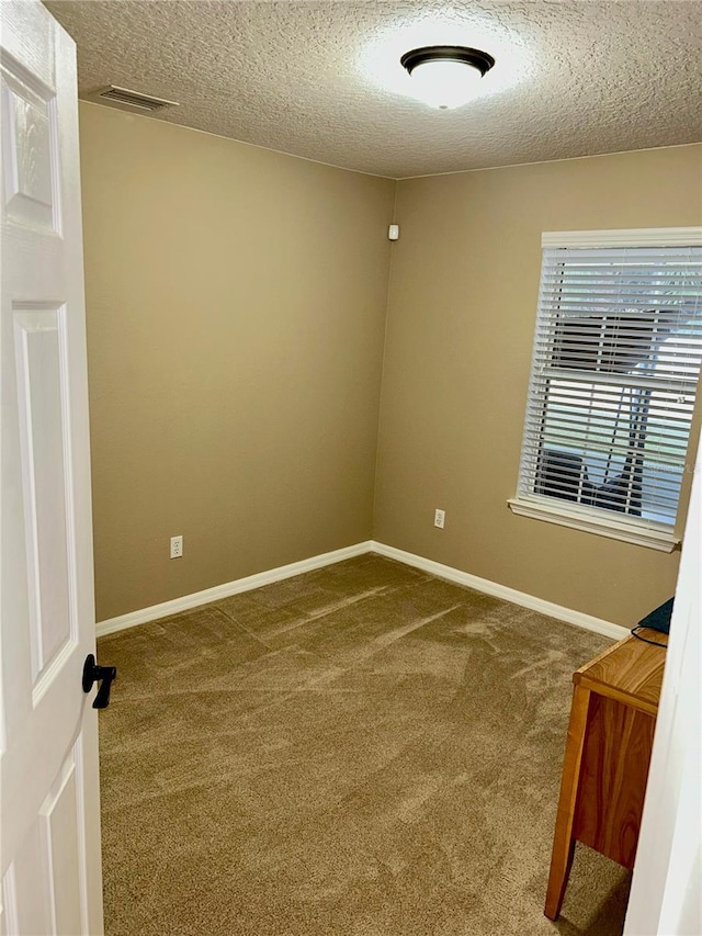 carpeted spare room featuring a textured ceiling