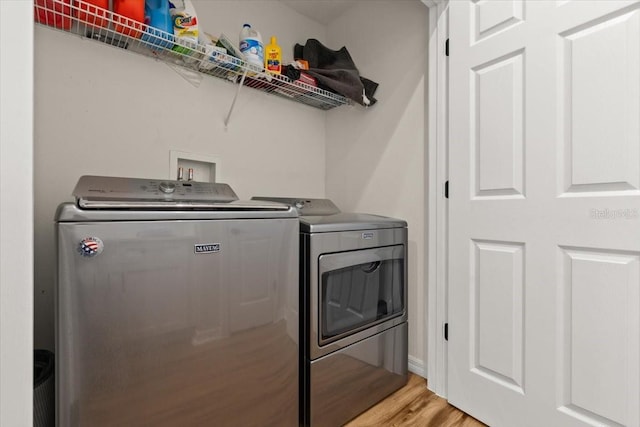 clothes washing area featuring independent washer and dryer and light wood-type flooring