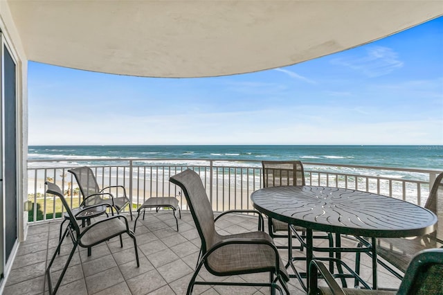 balcony with a water view and a beach view