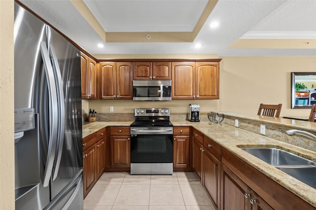 kitchen featuring stainless steel appliances, sink, a raised ceiling, light tile patterned flooring, and crown molding