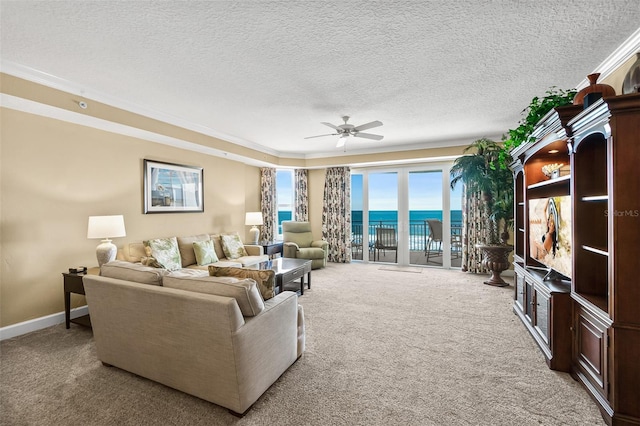 living room featuring ceiling fan, light colored carpet, ornamental molding, and a textured ceiling