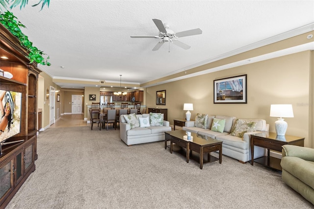 carpeted living room with a textured ceiling, ceiling fan, and crown molding