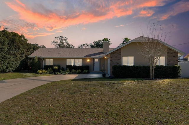 ranch-style home featuring a lawn