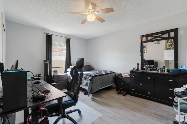 bedroom featuring a textured ceiling, light hardwood / wood-style flooring, and ceiling fan