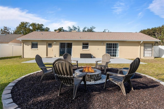 rear view of property featuring a yard, a fire pit, and a patio area