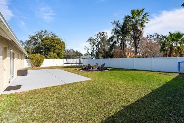 view of yard with a trampoline and a patio