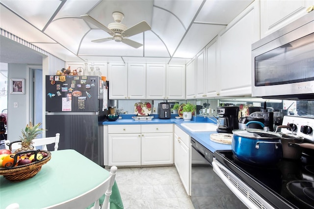 kitchen with stainless steel appliances, sink, and white cabinets