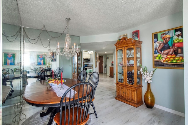 dining space featuring light hardwood / wood-style flooring and a textured ceiling