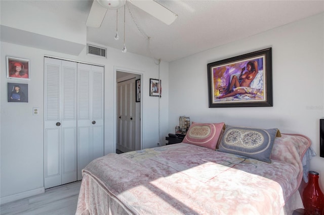 bedroom featuring ceiling fan, light hardwood / wood-style floors, and a closet