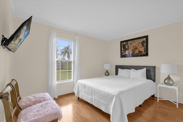 bedroom featuring light hardwood / wood-style flooring and crown molding