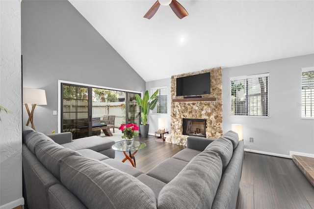 living room with high vaulted ceiling, a healthy amount of sunlight, dark wood-type flooring, and a fireplace