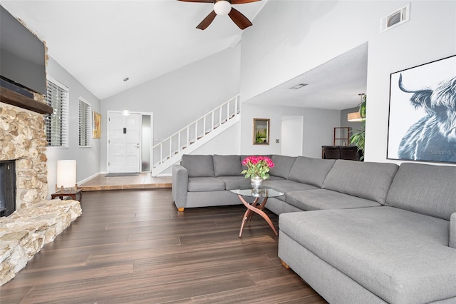 living room with ceiling fan, dark hardwood / wood-style flooring, vaulted ceiling, and a fireplace