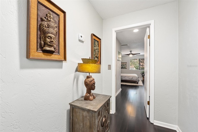 hallway with hardwood / wood-style flooring and a textured ceiling