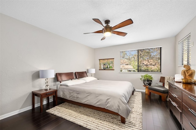 bedroom featuring dark wood-type flooring, a textured ceiling, and ceiling fan