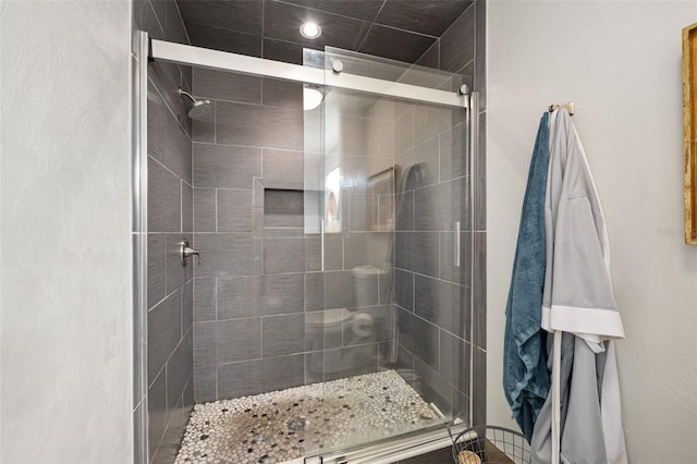 bathroom with a shower with door