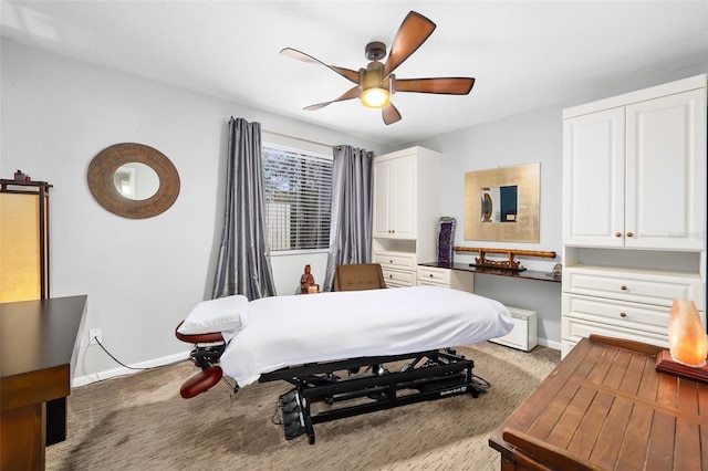 bedroom with ceiling fan, light carpet, and built in desk