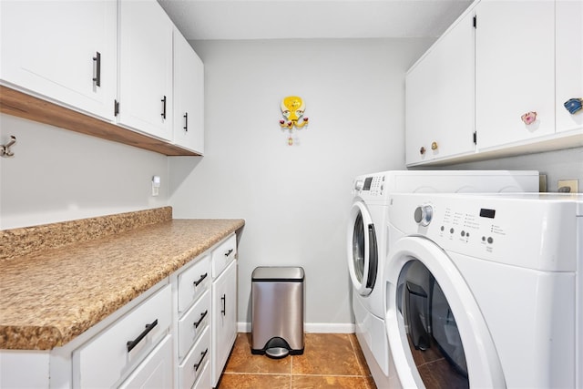 clothes washing area featuring cabinets, light tile patterned floors, and washing machine and clothes dryer