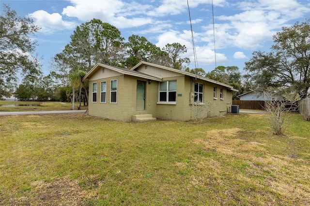 view of front of home with a front lawn and central air condition unit