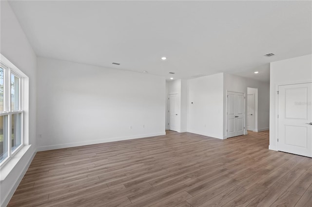 spare room featuring a healthy amount of sunlight and light wood-type flooring