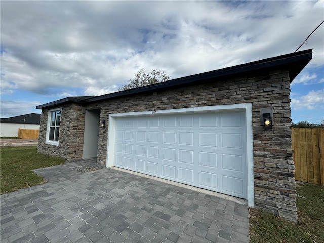 exterior space with decorative driveway and fence