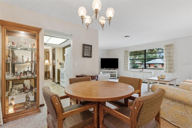 carpeted dining space with a notable chandelier