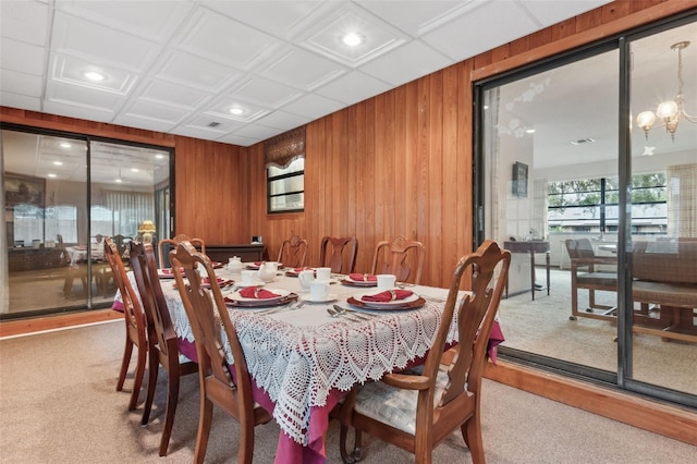 dining room with an inviting chandelier and light colored carpet