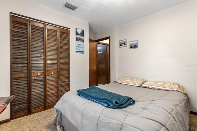 carpeted bedroom featuring a textured ceiling and a closet