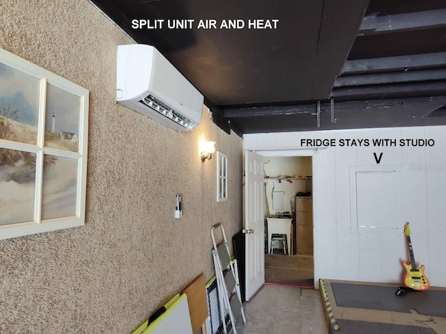 interior space with a wall mounted air conditioner and tile patterned flooring