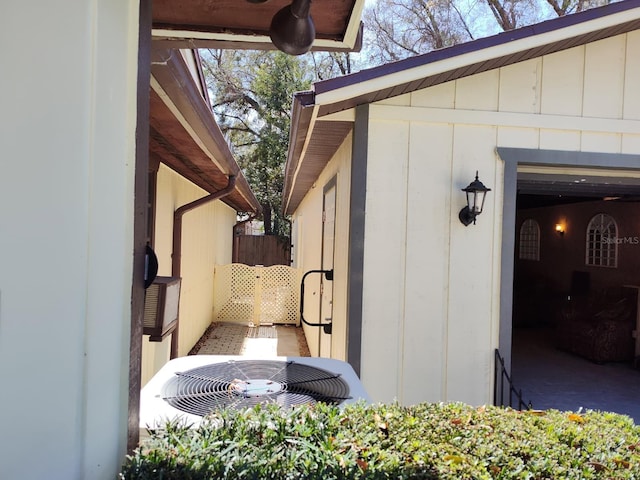 view of home's exterior featuring board and batten siding, fence, and central air condition unit