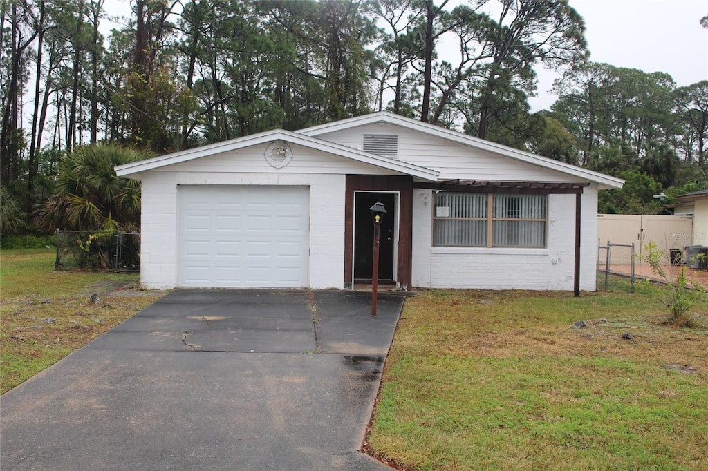 ranch-style house featuring a garage and a front yard